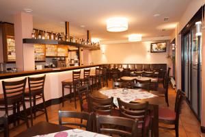 een restaurant met tafels en stoelen en een bar bij Advantage Appartements Hotel in Neurenberg