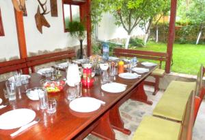 a long wooden table with plates and glasses on it at Beroe in Sveti Vlas