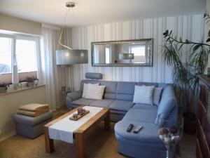 a living room with a blue couch and a table at Ferienhaus Kunas in Lübeck