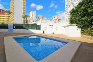 a swimming pool in front of a building with tall buildings at Apartamentos Lepanto 21 Levante Area in Benidorm