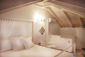 a bedroom with a white bed and a chandelier at To Spiti - Pelion House in Kala Nera