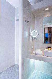 a bathroom with a sink and a mirror at Poseidon of Paros Hotel & Spa in Chrissi Akti