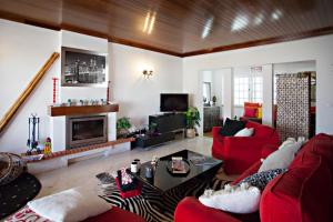 a living room with red furniture and a fireplace at Villa Monaco in Faro