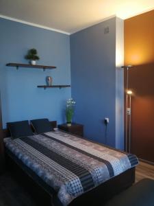 グディニャにあるApartament PMCの青い壁のベッドルーム(ベッド付)