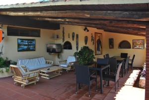 a patio with chairs and tables and a tv at Hotel Brutium in Tortora