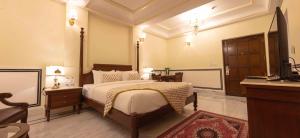 een slaapkamer met een bed en een televisie. bij Laxmi Palace in Dausa