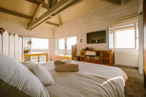 a bedroom with a large white bed with a flat screen tv at Villa Lodge Natureo in Seignosse