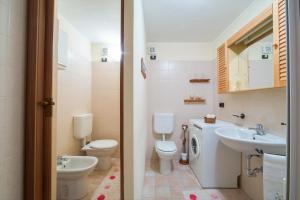 a bathroom with a toilet and a sink at Appartamento Pila Bellevue in Pila +30 photos