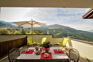 uma mesa e cadeiras numa varanda com vista para as montanhas em Appartamento Pila Bellevue em Pila