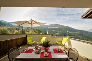 a table and chairs on a balcony with a view of mountains at Appartamento Pila Bellevue in Pila