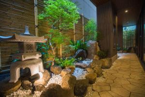 einen Garten mit einer Pagode in der Mitte eines Gebäudes in der Unterkunft Hotel Yu-shu in Osaka