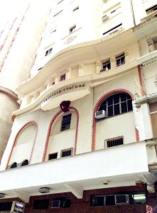 um edifício branco com acabamentos vermelhos e janelas em Itajubá Hotel no Rio de Janeiro