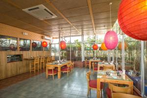 ein Restaurant mit Holztischen und Stühlen und roten Laternen in der Unterkunft Ascott Palace Dhaka in Dhaka
