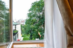 una ventana abierta con vistas a un árbol en Bed & Breakfast Garden40 en Belgrado
