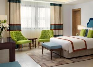 Rúm í herbergi á Al Najada Doha Hotel Apartments by Oaks