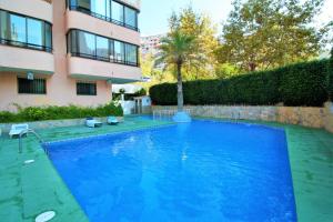 una gran piscina azul junto a un edificio en Cadiz 4-B, en Benidorm