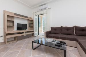 - un salon avec un canapé et une télévision dans l'établissement Apartments Kula, à Risan