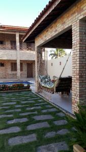 a courtyard of a house with a patio with a swing at Chalés 4 Estações in Beberibe