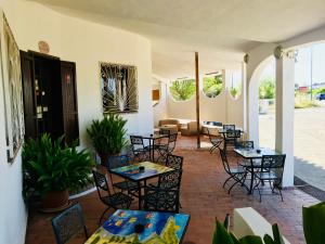 a patio with tables and chairs in a room at Hotel Su Meriagu in Capitana