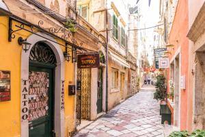 Une allée avec une porte verte dans un bâtiment dans l'établissement Kantouni Bizi Myranthis Apartment, à Corfou