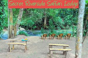 a group of chairs and benches in a park at Secret River Side Safari Lodge in Udawalawe