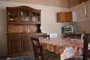 una cocina con armarios de madera y una mesa con sillas. en Angelo Holiday Home en Valderice