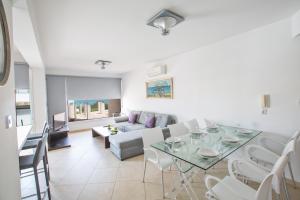 a living room with a table and a couch at Pallinio Fig Tree Bay Apartments in Protaras