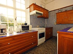 ブイヨンにあるQuaint Holiday Home in Bouillon Ardennesのキッチン(木製キャビネット、白いコンロ付)