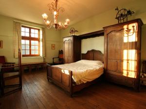 a bedroom with a large wooden bed and a chandelier at Quaint Holiday Home in Bouillon Ardennes in Bouillon