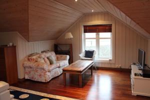 ein Wohnzimmer mit einem Sofa und einem Tisch in der Unterkunft Skipperhus Skjærhalden in Skjærhollen