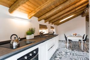 a kitchen with wooden ceilings and a table with chairs at Casa Vacanza Etna Dream in Zafferana Etnea