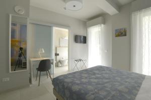 a bedroom with a bed and a desk and a chair at Hotel Villa MIKI in Bordighera