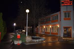 a street light in front of a building at night at Motel Citadela 023 in Zrenjanin