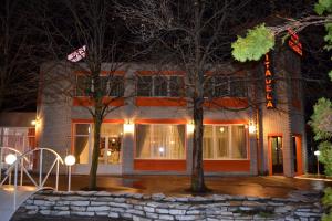 uma casa de tijolos com árvores em frente em Motel Citadela 023 em Zrenjanin