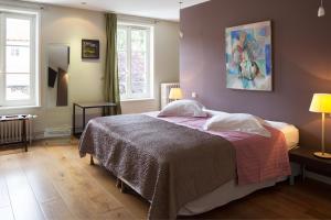 a bedroom with a bed and a painting on the wall at Maison d'Hôte de Myon in Nancy