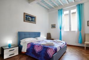 a bedroom with a bed with a blue headboard and blue curtains at Silver Sword Suite in Florence