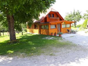 een blokhut met een veranda en een boom bij Tourist Farm Znidarjevi in Kožljek