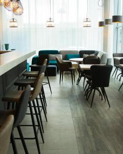 un restaurante con mesas y sillas y un sofá en Concept Hotel, en Khimki