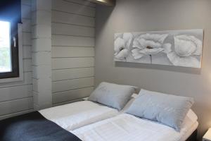 una camera con un letto bianco con due cuscini di Naava Chalet Pikku Panda (305) a Ähtäri