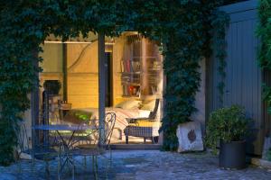 a patio with a table and chairs and a bed at Maison d'Hôte de Myon in Nancy