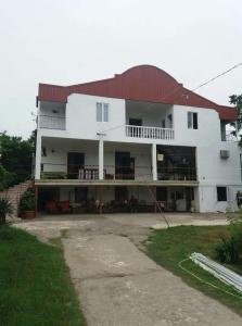 a large white building with a red roof at Guest House TiAni in Kobuleti