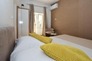 1 dormitorio con 1 cama con manta amarilla en Rooms Patricija, en Zadar