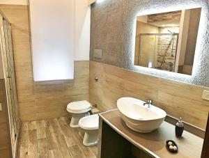 a bathroom with a sink and a toilet and a mirror at Casa Vacanza nel cuore di Castellammare del golfo in Castellammare del Golfo +18 photos