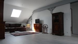 a living room with a couch and a tv at Chambres d'hotes Maison Gille in Nuits-Saint-Georges