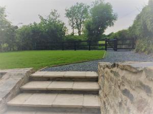a park with stairs and a fence and grass at The Bakery in Llanddeiniol