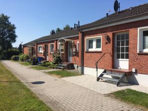 ein Backsteinhaus mit einer Bank davor in der Unterkunft „Lüttje Nüst“ in Emden