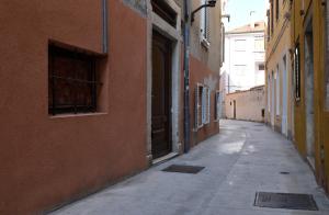 un callejón vacío con un edificio y una puerta abierta en Rooms Patricija, en Zadar