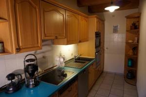 a kitchen with wooden cabinets and a sink at Ferienwohnung Näfelt in Gunzenhausen +3 photos