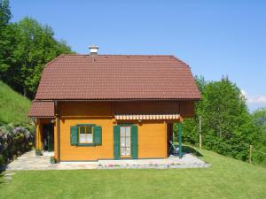 een klein geel huis met een bruin dak bij Almchalet Orter in Deutschberg