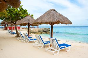 una fila di sedie e ombrelloni su una spiaggia di Playa Azul Cozumel a Cozumel
